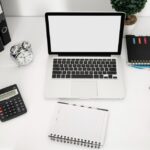 Espace de travail organisé avec un ordinateur portable, une calculatrice de bureau et des fournitures, alternative à une calculatrice en ligne