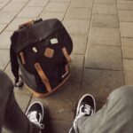 person wearing black-and-white Vans Old Skool sneakers
