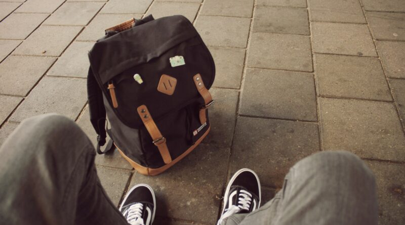 person wearing black-and-white Vans Old Skool sneakers